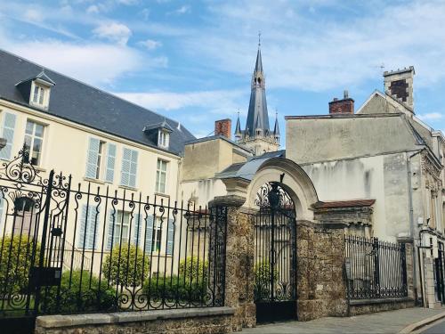 un edificio con una valla negra y una iglesia en Le Secret de Louise, en Épernay