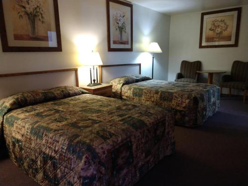 a hotel room with two beds and a table at Southwest Motel in Grants