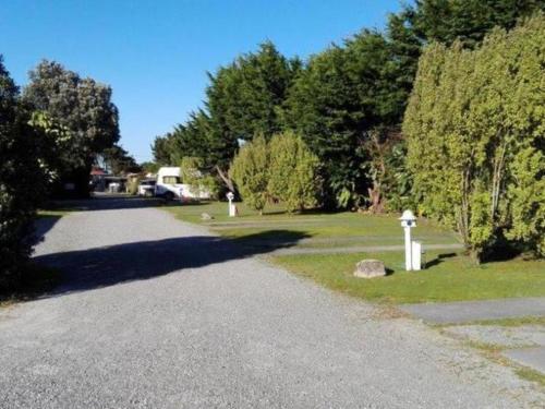 a road with a white fire hydrant on the side at Greymouth Kiwi Holiday Park & Motels in Greymouth