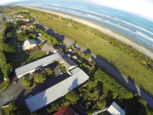 an aerial view of a house and the beach at Greymouth Kiwi Holiday Park & Motels in Greymouth