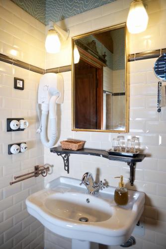 une salle de bain avec un lavabo et un miroir dans l'établissement La Minauderie, à Écully