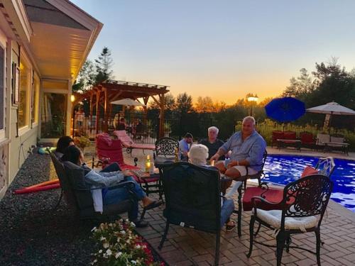 a group of people sitting around a patio near a pool at The Inn at Quail Run in Wilmington