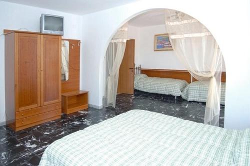 - une chambre avec 2 lits et une porte voûtée dans l'établissement Locanda Al Castello, à Peschici