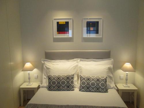 a bedroom with a white bed with two nightstands and two lamps at 4PortoApartments#2 in Porto