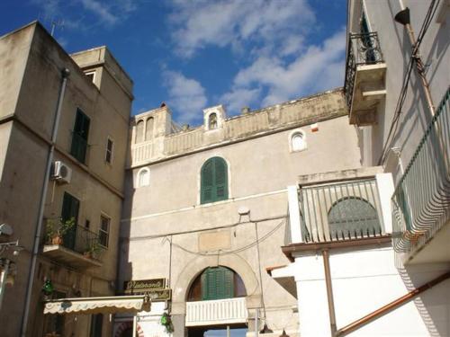 a large building with green windows and a balcony at Locanda Al Castello in Peschici