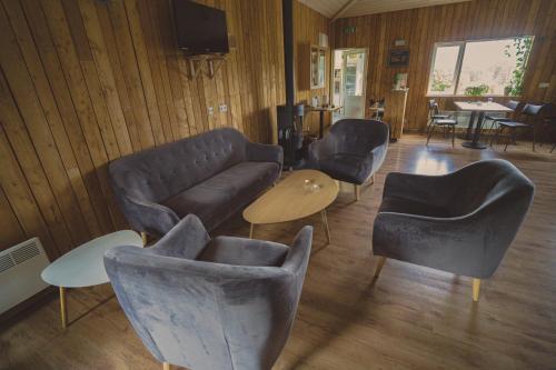 a living room with a couch and chairs and a table at Hengifoss Guesthouse in Valþjófsstaður