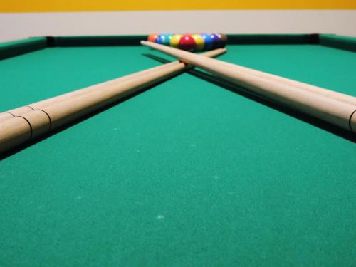 two cue sticks on top of a pool table at Hotel Flamboyant Taubate in Taubaté