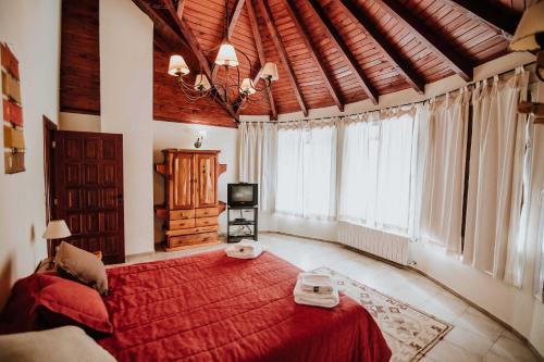 1 dormitorio con 1 cama grande de color rojo y ventanas en Las Asturianas en San Carlos de Bariloche