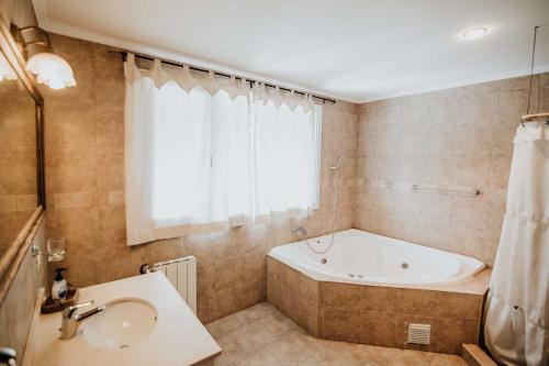 y baño con bañera y lavamanos. en Las Asturianas en San Carlos de Bariloche
