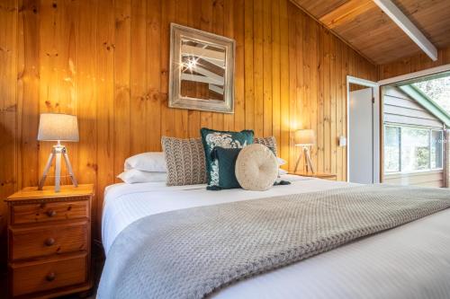 a bedroom with a bed with wood paneled walls at Kondalilla Eco Resort in Montville