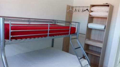 a towel rack with red towels on it in a bathroom at résidence la petite calebasse in Quartiers Anse à lʼÂne
