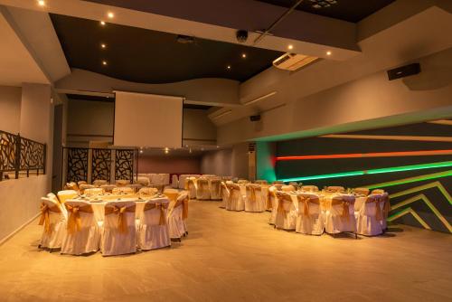 a room with rows of tables with white chairs at Hotel St. George in Celaya