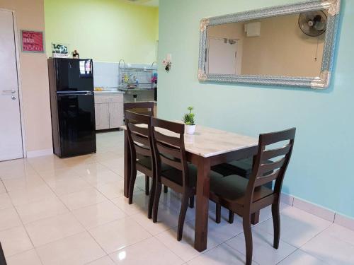 a dining room with a table and chairs and a mirror at DinDas Family Stay @ Labuan in Labuan