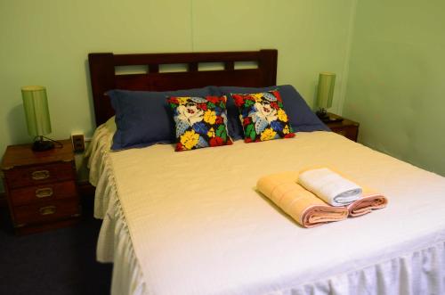 a bed with two towels and pillows on it at Hostal Aventura Austral in Punta Arenas