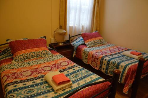 two beds sitting next to each other in a room at Hostal Aventura Austral in Punta Arenas