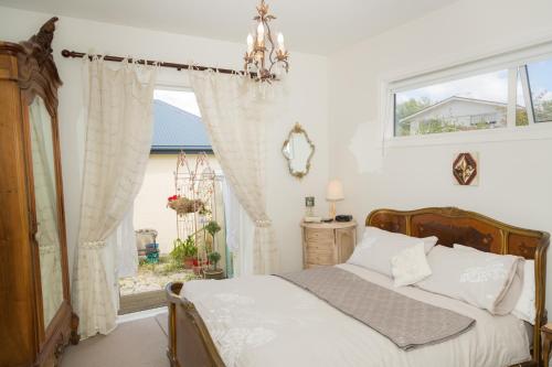 - une chambre avec un lit et une fenêtre dans l'établissement Papanui Paris inspired Apartment, à Christchurch