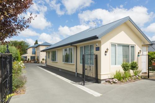 a small house with a fence in a driveway at Papanui Paris inspired Apartment in Christchurch