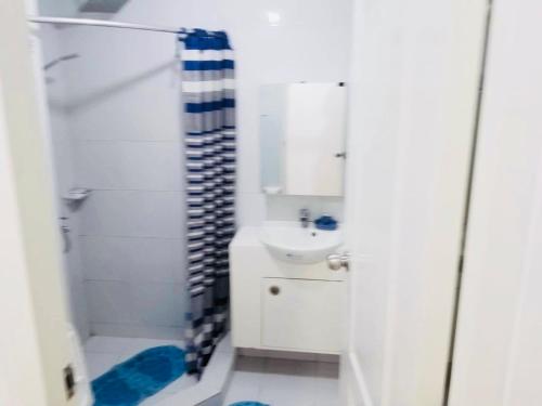 a white bathroom with a shower and a sink at Fully Furnished 1 Bedroom Condo at One Oasis, Cagayan de Oro City in Cagayan de Oro