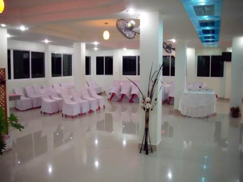a banquet hall with white tables and white chairs at Euro Boutique Hotel in Chumphon