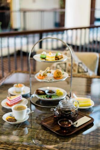 a table with plates of food and cups of coffee at VOUK Hotel and Suites Nusa Dua Bali in Nusa Dua
