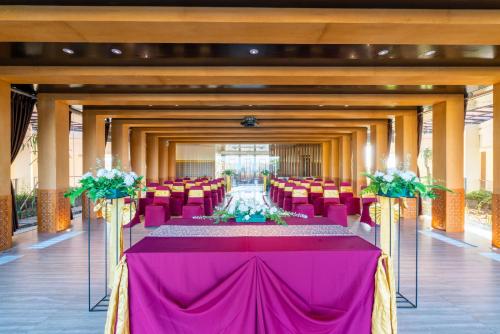 a long banquet hall with purple tables and chairs at VOUK Hotel and Suites Nusa Dua Bali in Nusa Dua