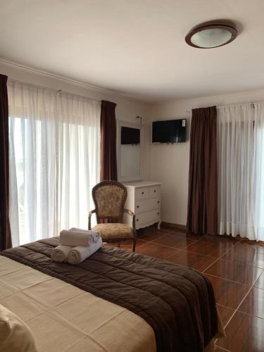 a bedroom with a large bed with a chair and a dresser at Teanehi Bed & Breakfast in Hanga Roa