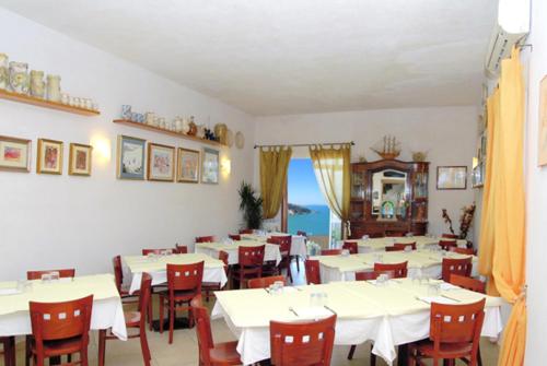 une salle à manger avec des tables blanches et des chaises rouges dans l'établissement Locanda Al Castello, à Peschici