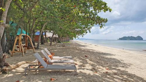 a row of chairs on a beach with a playground at Koh Jum Delight Beach in Ko Jum