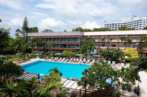 a hotel with a swimming pool in front of a building at Basaya Beach Hotel & Resort in Pattaya