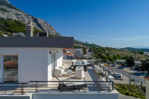 a balcony of a building with chairs and a street at Villa Palladium in Makarska