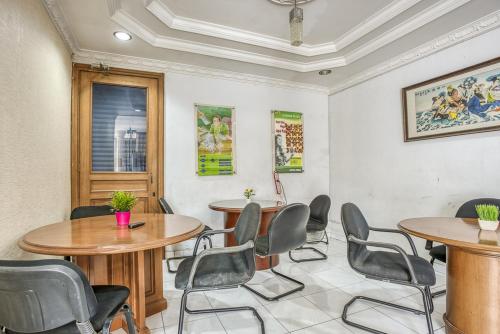 uma sala de reuniões com duas mesas e cadeiras em RedDoorz Hostel @ Feliz Noche Cengkareng em Jacarta