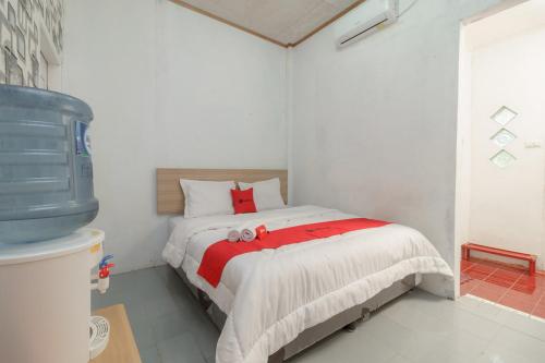 a bedroom with a bed with two teddy bears on it at RedDoorz Syariah near Paradiso Beach Sabang in Sabong