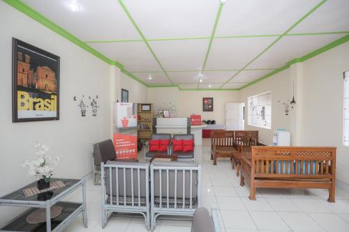 una sala de estar con sillas y mesas y una habitación con en RedDoorz near Bundaran Kecil Palangkaraya en Palangkaraya