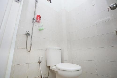 パランカラヤにあるRedDoorz near Bundaran Kecil Palangkarayaのトイレとシャワー付きの白いバスルーム