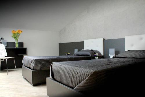 a bedroom with two beds and a table with flowers at Giulimà B&B in Rocchetta SantʼAntonio