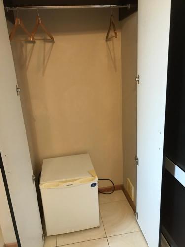 a small refrigerator in a room with a closet at Motel Sujet in Bohodukhiv