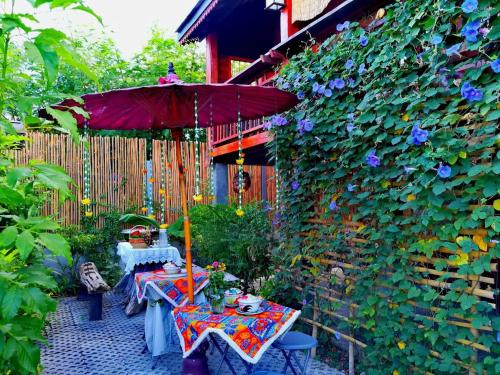 a patio with two tables and an umbrella at Lampang Lanna Home in Lampang