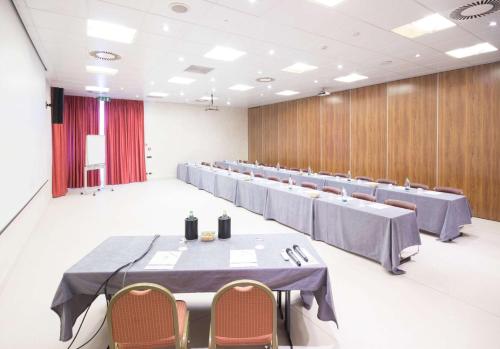 a large room with tables and chairs in it at Best Western Modena District in Campogalliano