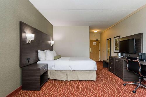 a hotel room with a bed and a flat screen tv at Best Western Inn On The Bay in Owen Sound