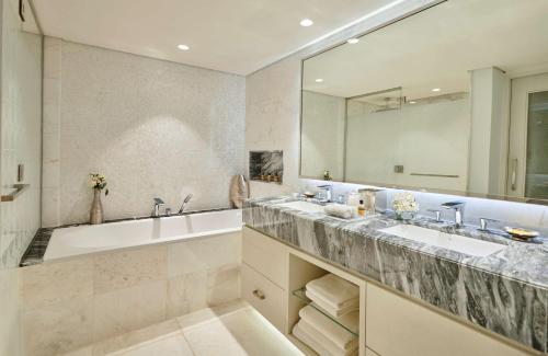 a bathroom with two sinks and a tub and a mirror at Hyatt Regency Addis Ababa in Addis Ababa