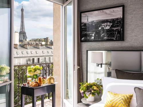 a bedroom with a view of the eiffel tower at Sofitel Paris Baltimore Tour Eiffel in Paris