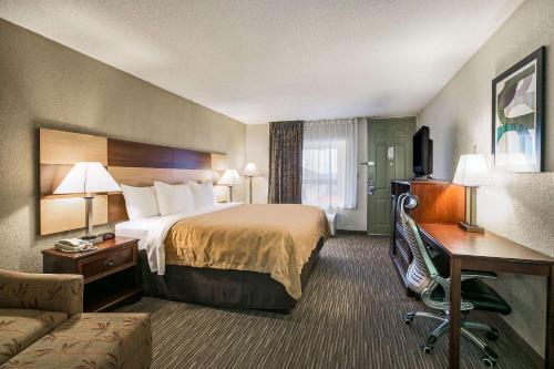 a hotel room with a bed and a couch at Quality Inn & Suites near Lake Eufaula in Eufaula
