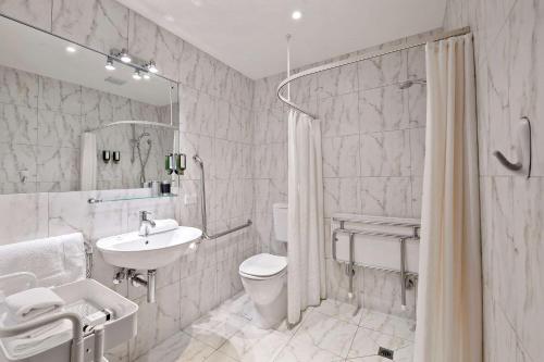 uma casa de banho branca com um lavatório, um WC e um chuveiro em The Classic Villa em Christchurch