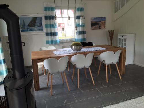 a dining room with a table and a wood stove at Reethaus Seeadler mit Sauna, Terrasse, Garten in Glowe