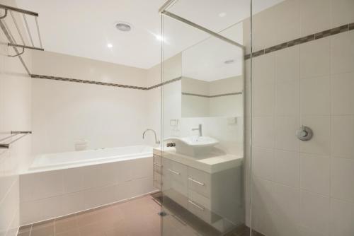a white bathroom with a sink and a bath tub at Breakwater Views by Kingscliff Accommodation in Cabarita Beach