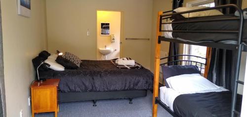 a bedroom with two bunk beds and a sink at Tombstone Motel, Lodge & Backpackers in Picton