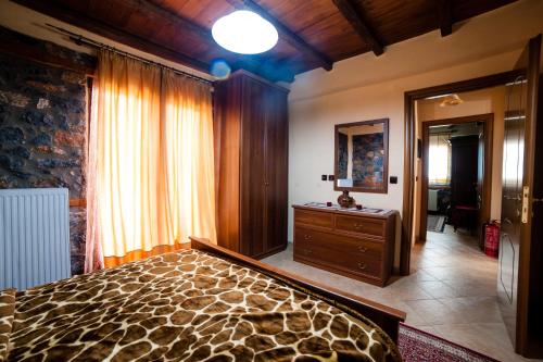 a bedroom with a bed and a dresser and a mirror at Eva Guesthouse in Palaios Agios Athanasios