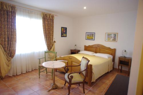 a bedroom with a bed and a table and chairs at Le Mas de l'Amandier in Saint-Saturnin-lès-Avignon