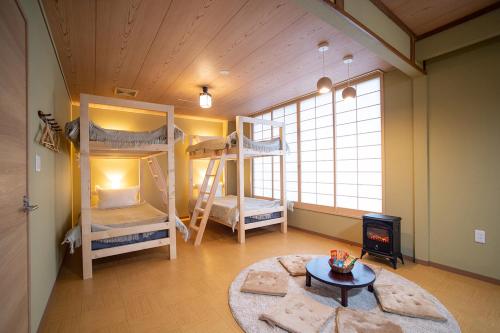函館市にあるGuesthouse tomoeドットコムの二段ベッド2台と暖炉が備わる客室です。