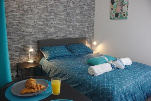 1 dormitorio con 2 camas y una mesa con un plato de cruasanes. en Lodge Fouchet - Studio proche Université, en Pau